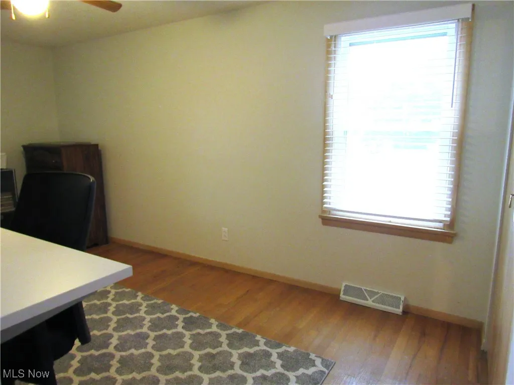 Office space with dark wood finished floors and ceiling fan