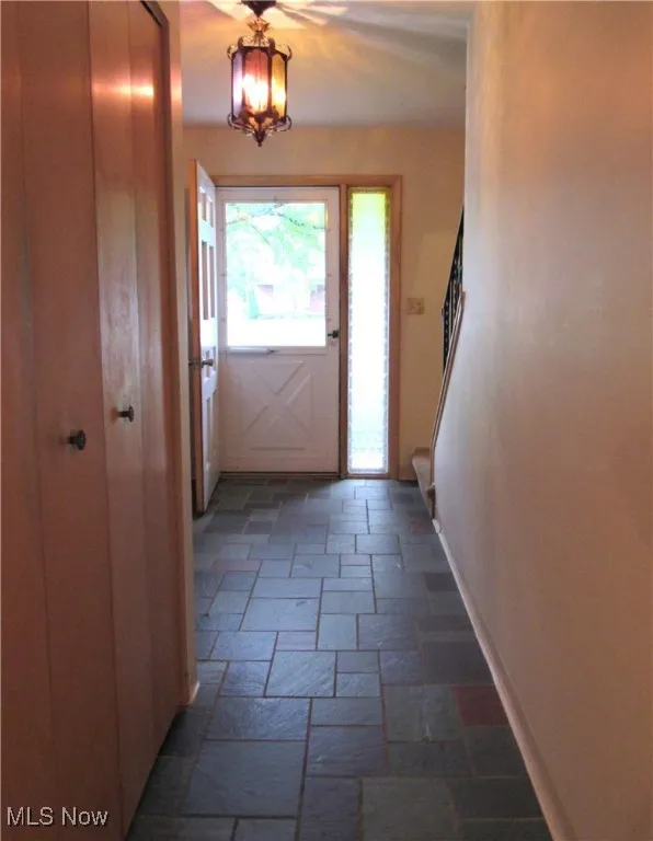 Foyer featuring stairway and stone tile floors