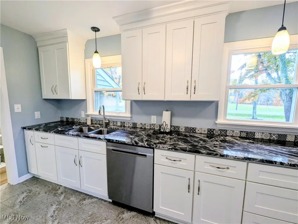 Kitchen with pendant lighting and dark stone counters