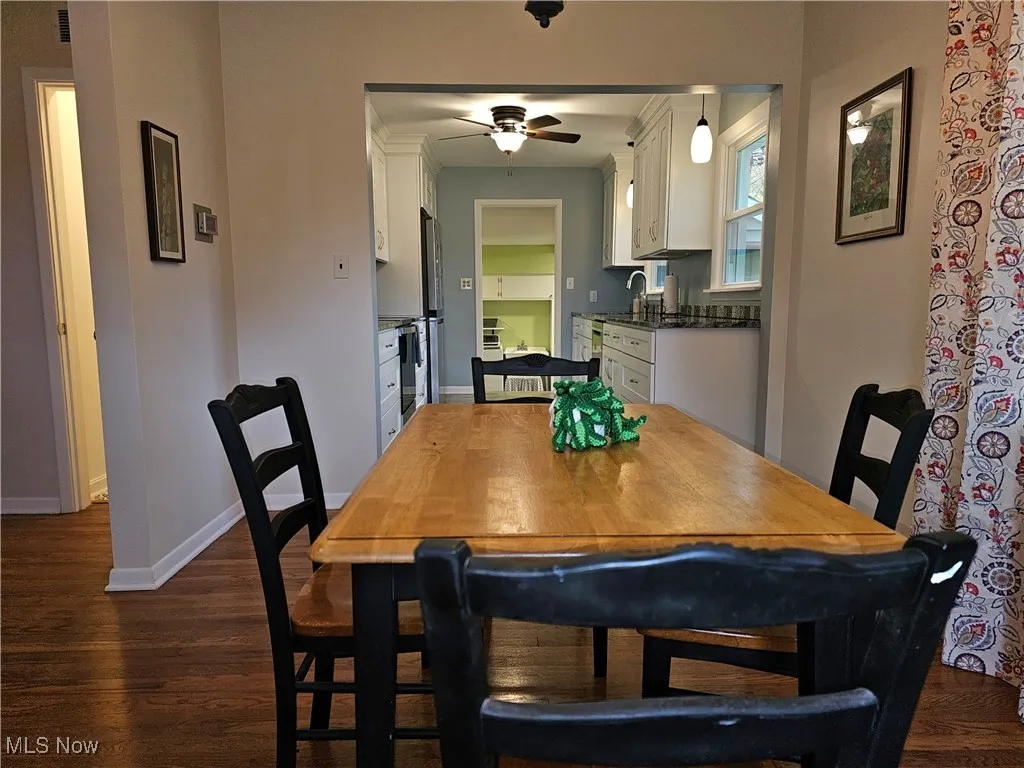 Dining space featuring dark wood-type flooring and a ceiling fan