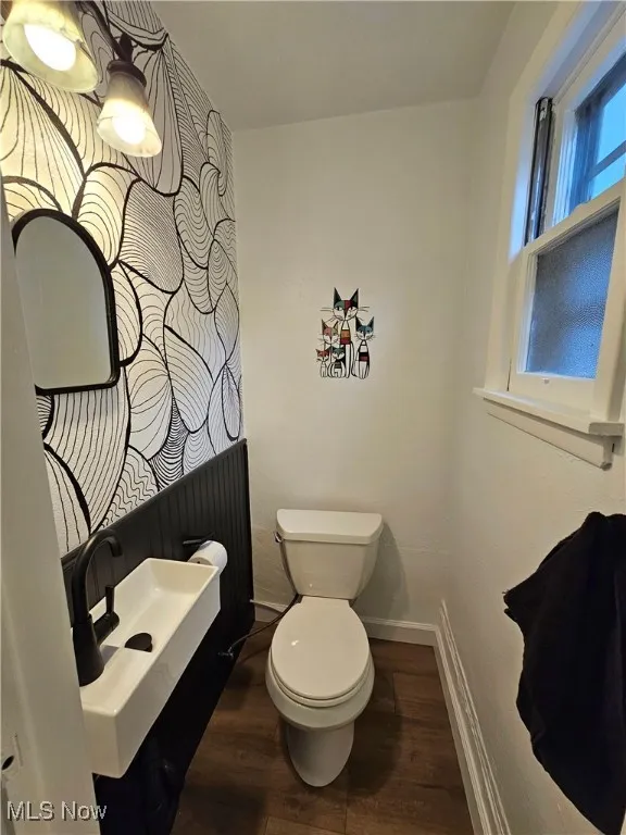 Half bathroom with dark wood-type flooring and vanity