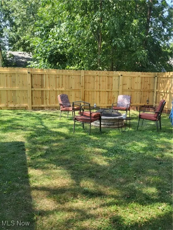 Fenced backyard with a fire pit