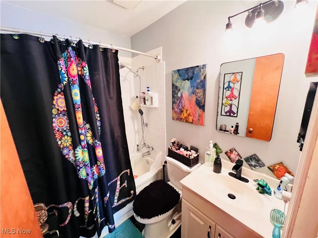 Full bathroom with vanity and shower / bath combo with shower curtain