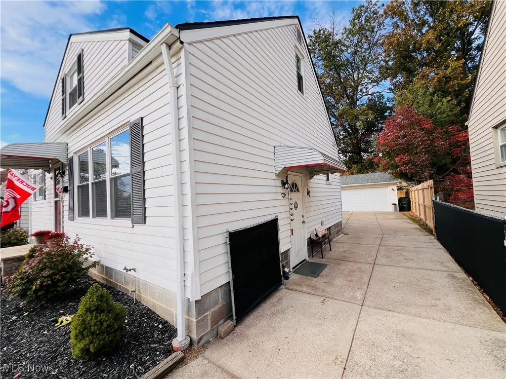 View of side of property with a detached garage