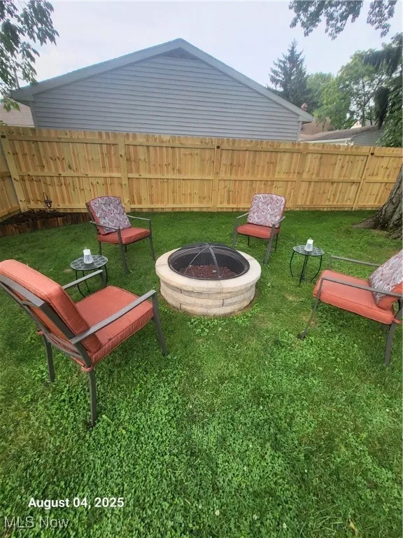 Fenced backyard featuring a fire pit