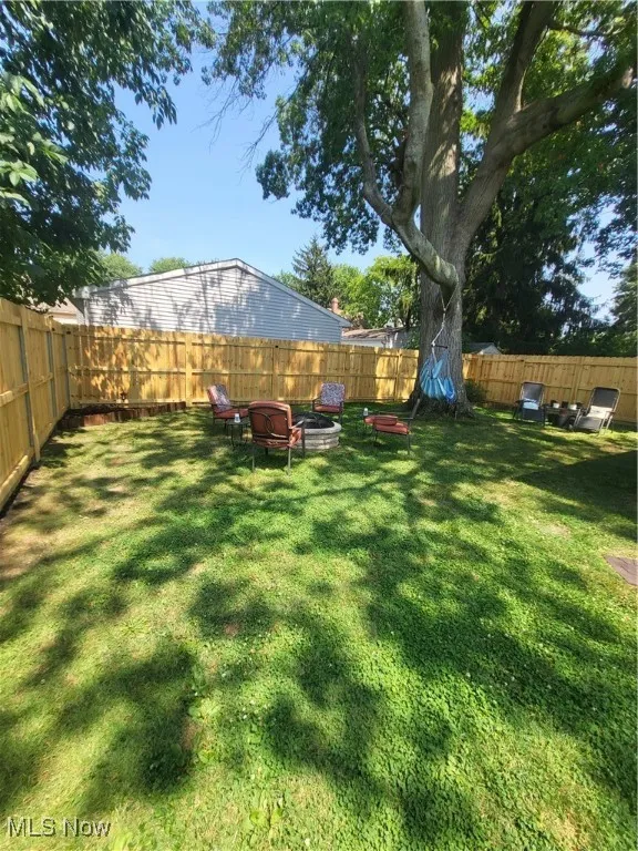 Fenced backyard with an outdoor fire pit