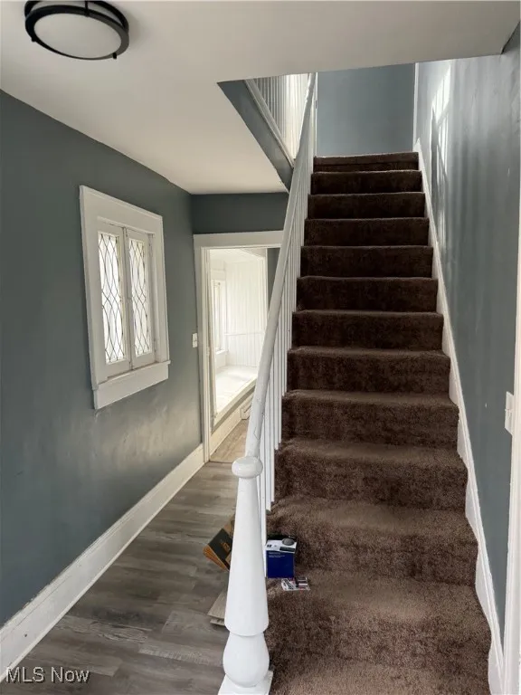 Stairway featuring baseboards and wood finished floors