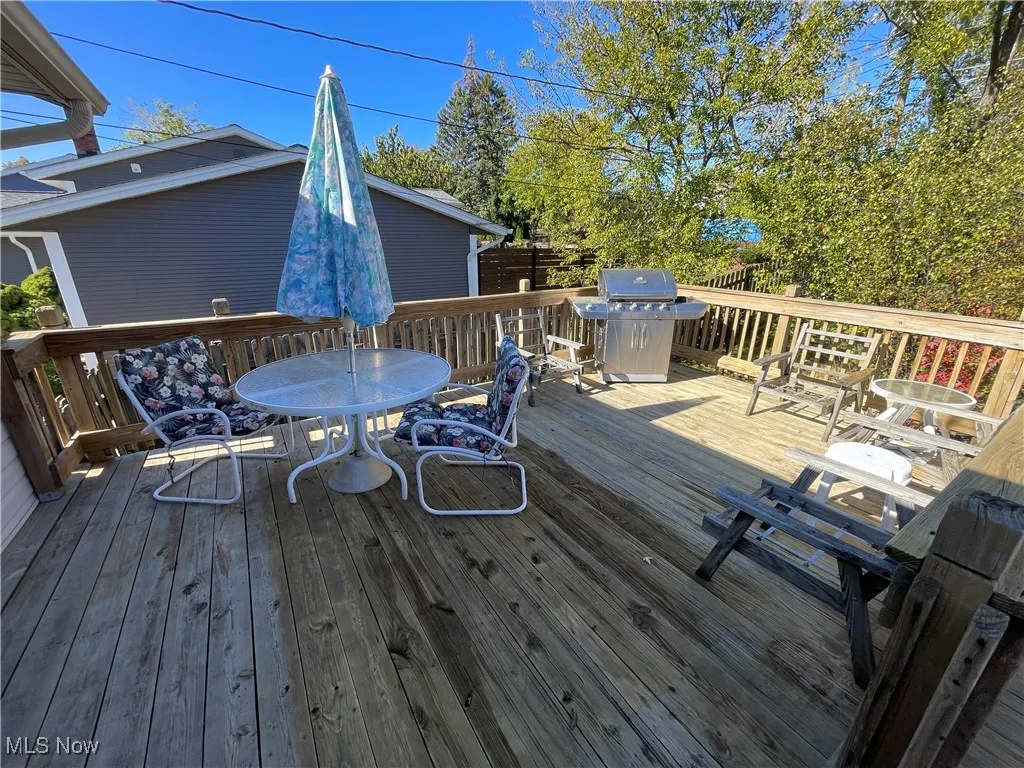 Wooden terrace with outdoor dining space and a grill
