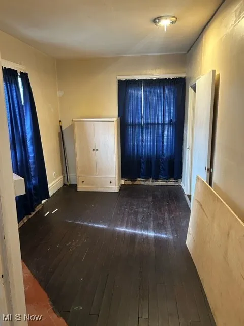 Unfurnished bedroom featuring dark wood-style flooring