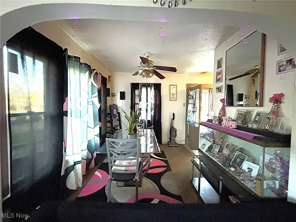Dining room featuring arched walkways and ceiling fan