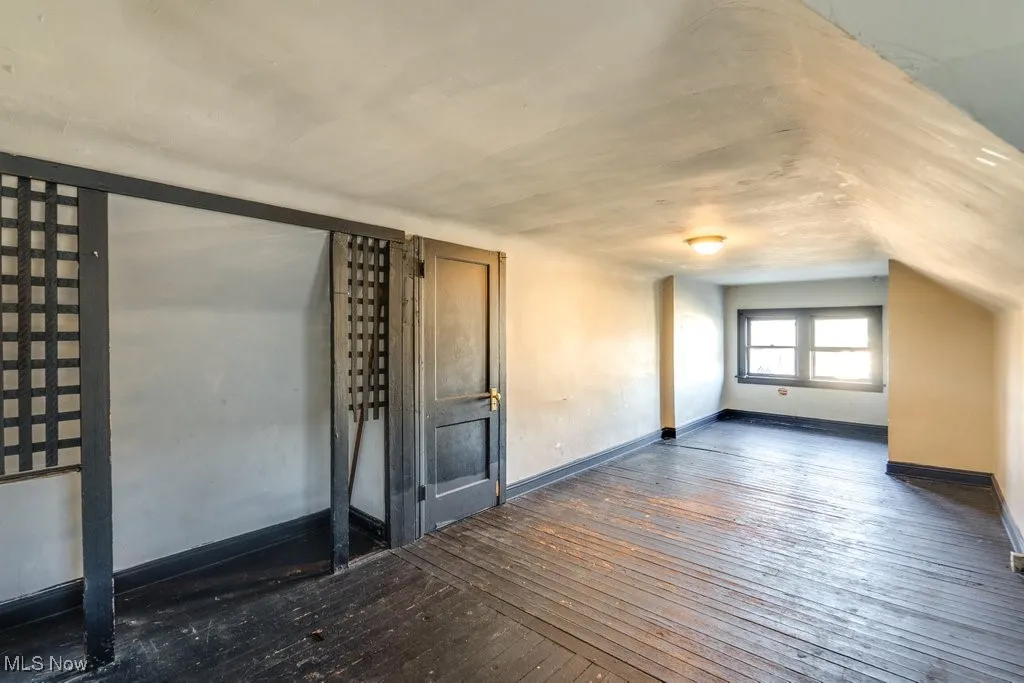 Additional living space with wood-type flooring and baseboards