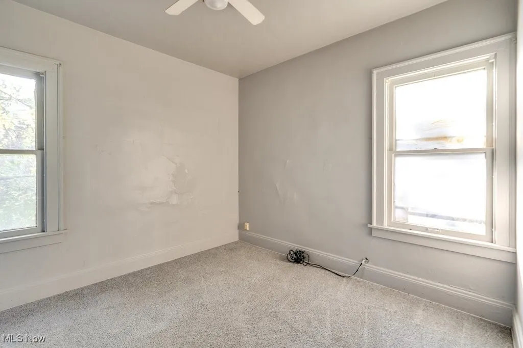 Carpeted spare room featuring baseboards