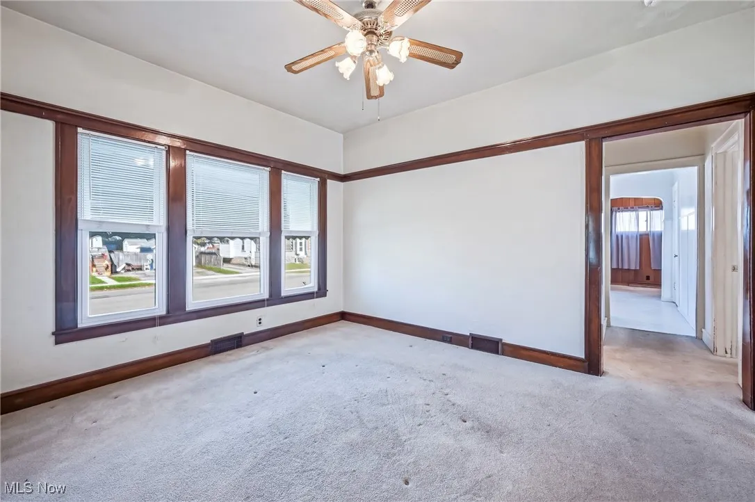 Large dining room with a trio of vinyl windows and ceiling fan