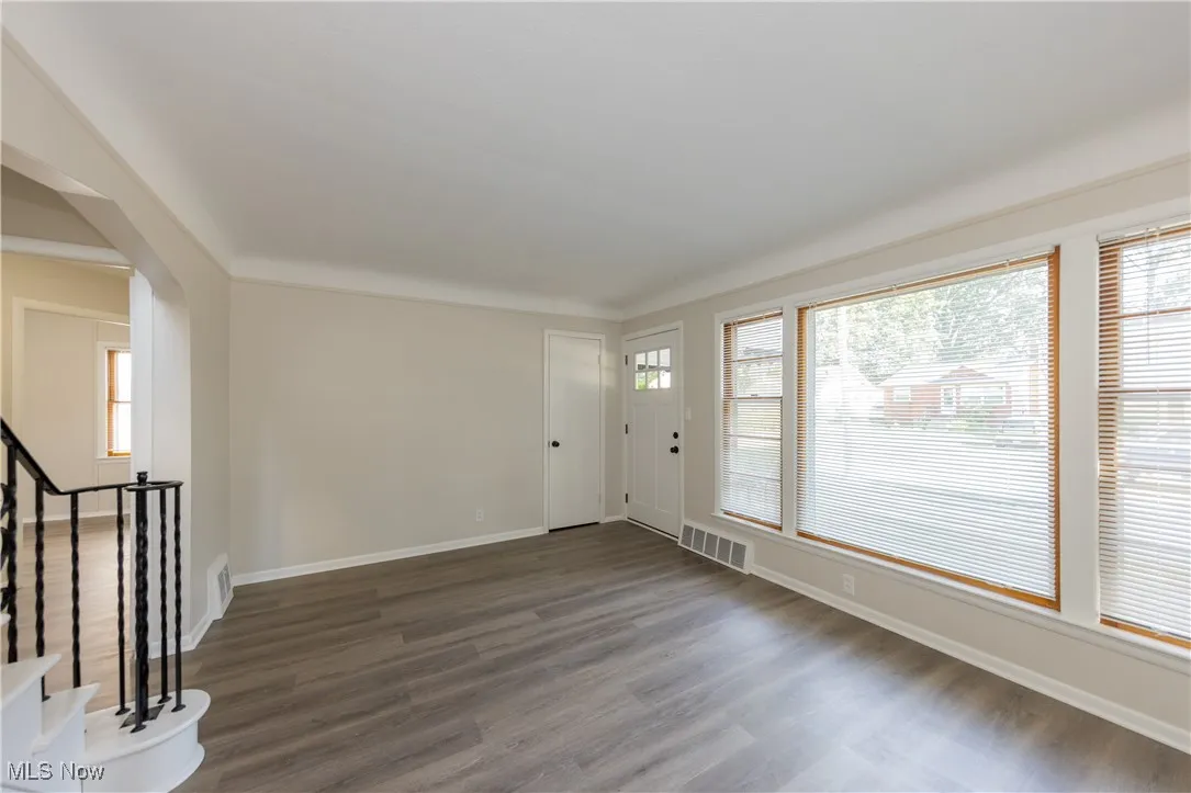Foyer entrance featuring wood finished floors and arched walkways