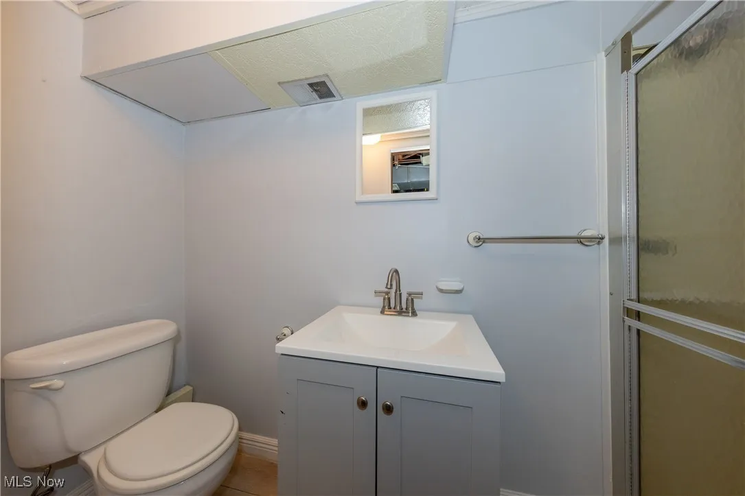 Full bath with a shower stall, vanity, and tile patterned floors
