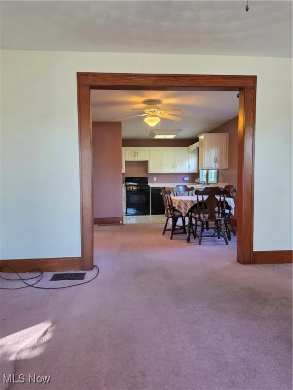Dining room featuring light carpet and a ceiling fan