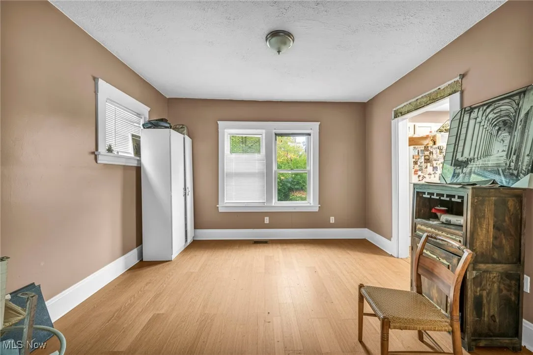 Living area featuring light wood-type flooring and a textured ceiling