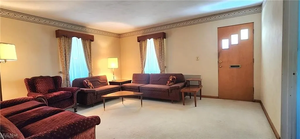 Carpeted living room featuring crown molding