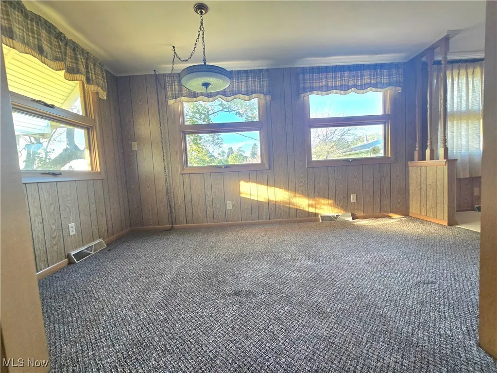 Empty room with carpet flooring and wood walls