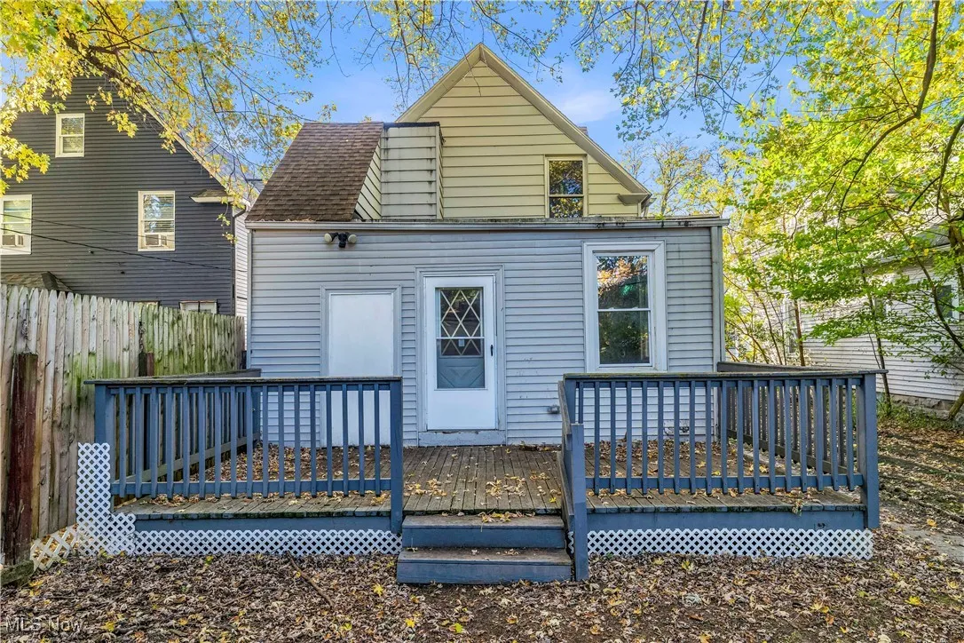 Back of house featuring a wooden deck and roof with shingles