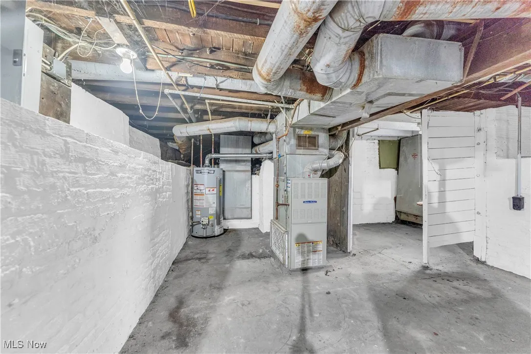Unfinished basement featuring water heater and heating unit