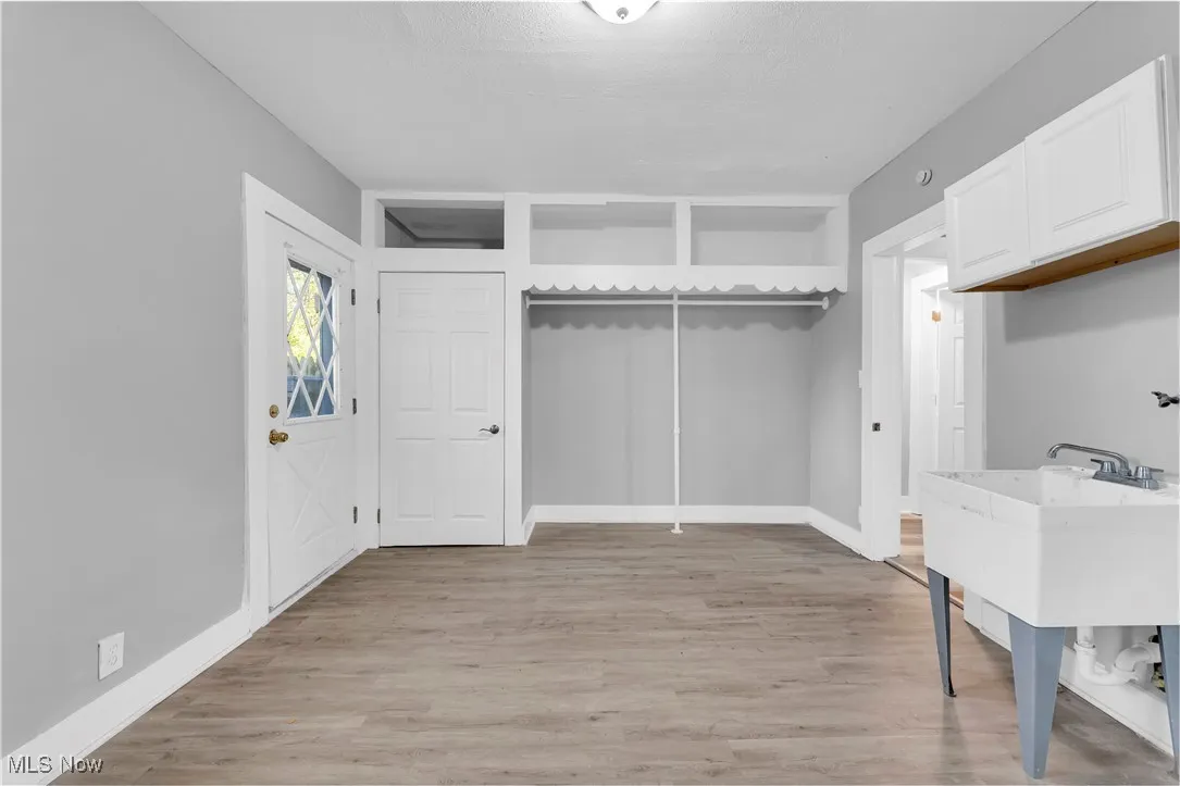 Spacious closet with light wood-style flooring and a sink