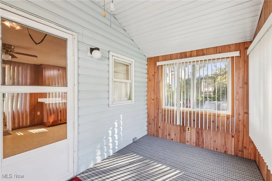 Unfurnished sunroom with lofted ceiling