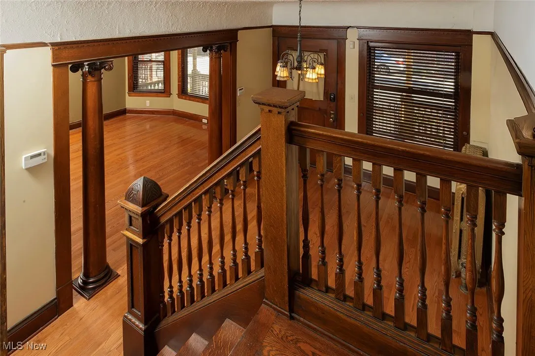 Stairs featuring wood finished floors and a chandelier