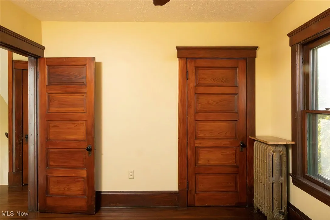 Bedroom featuring radiator, dark wood-type flooring, and a textured ceiling