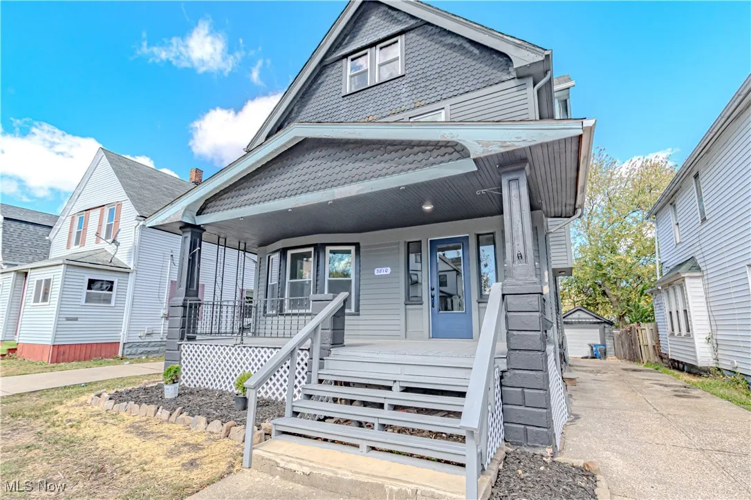 View of front of house with a porch and an outbuilding