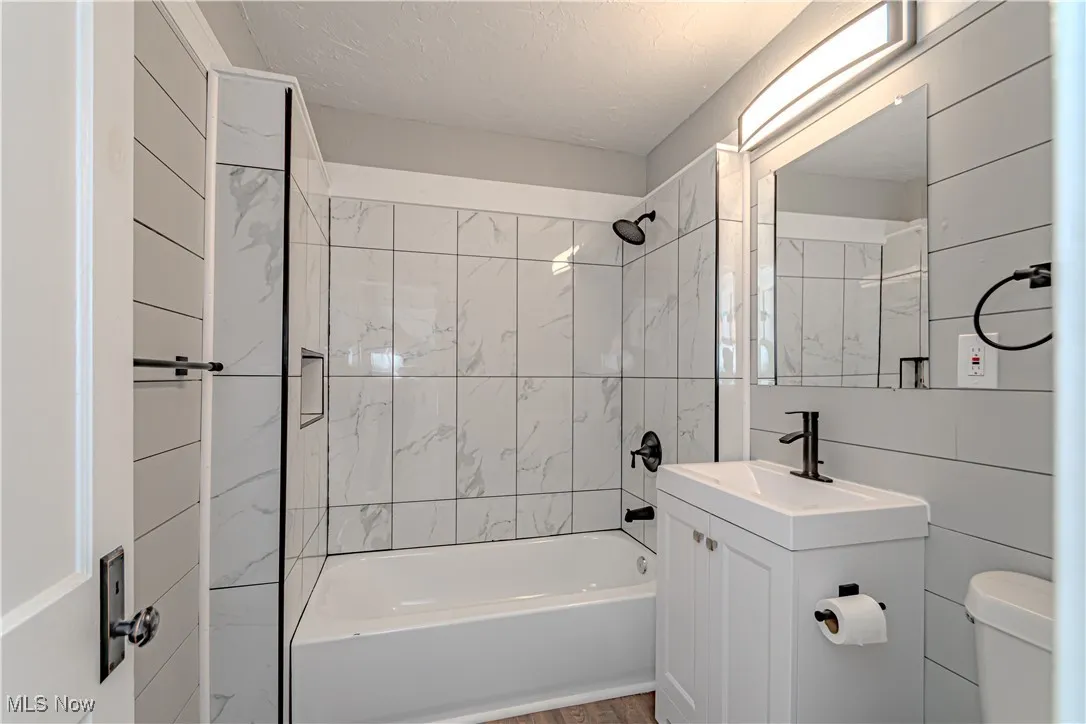 Bathroom featuring shower / washtub combination, vanity, and a textured ceiling