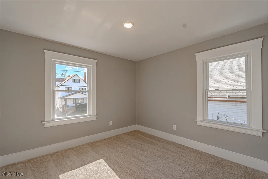 Spare room featuring baseboards and light colored carpet