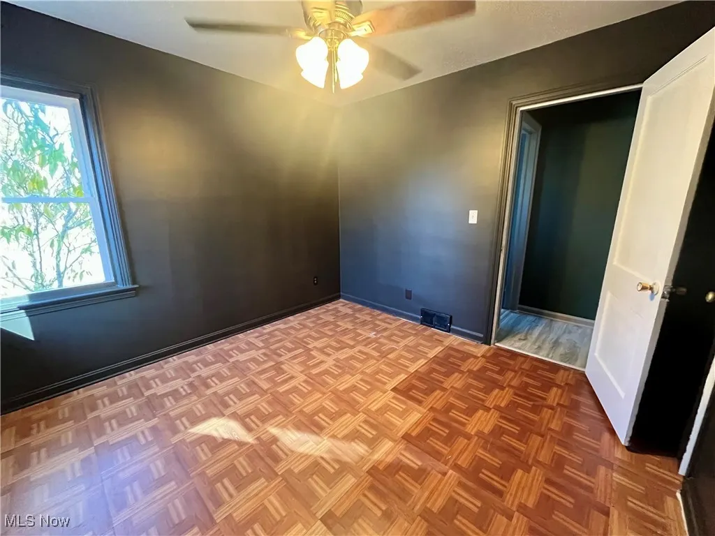 Empty room featuring a ceiling fan and baseboards
