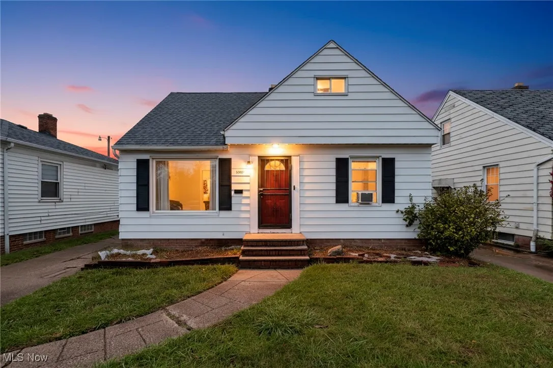Bungalow with a front yard and roof with shingles