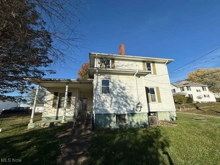 View of property exterior with a yard and a chimney