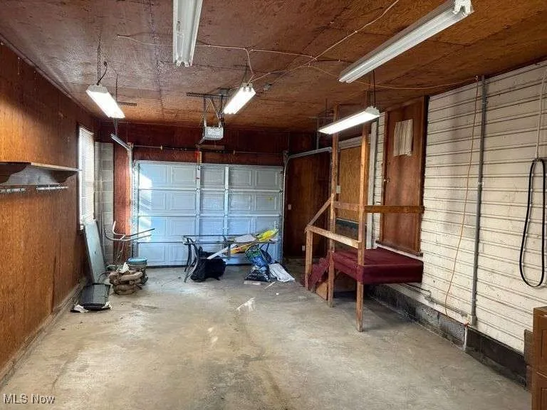 Garage with wood walls and a garage door opener