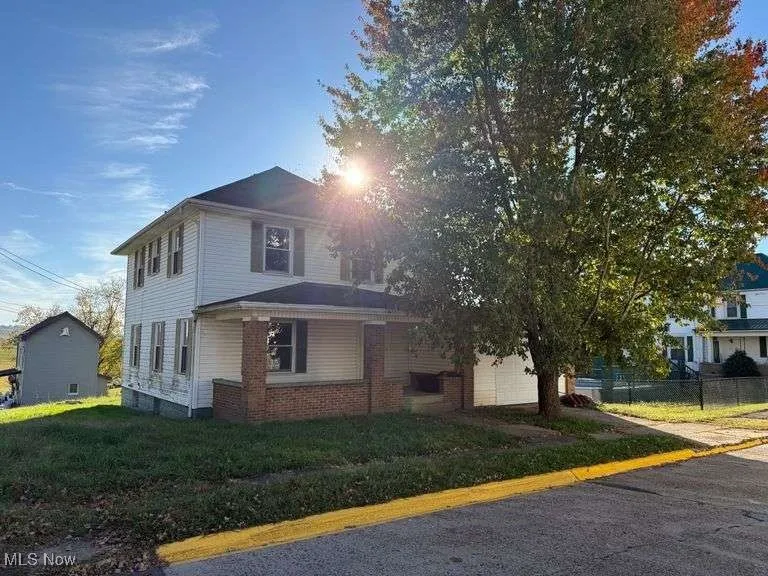 Traditional style home with a front yard, a garage, and brick siding