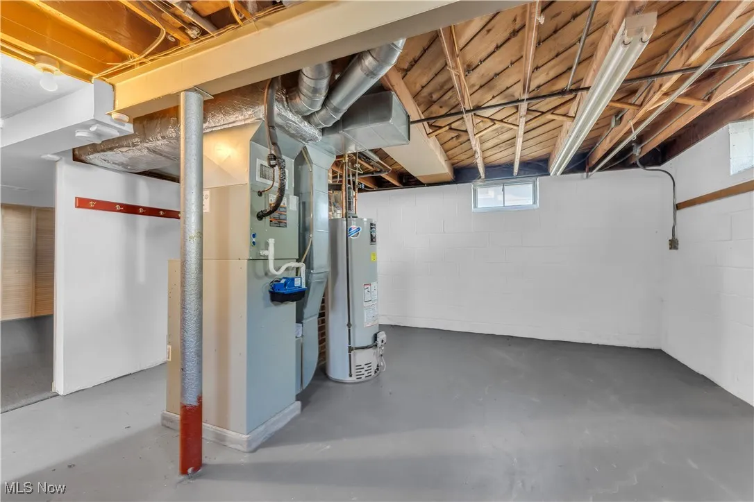 Below grade area featuring water heater and heating unit