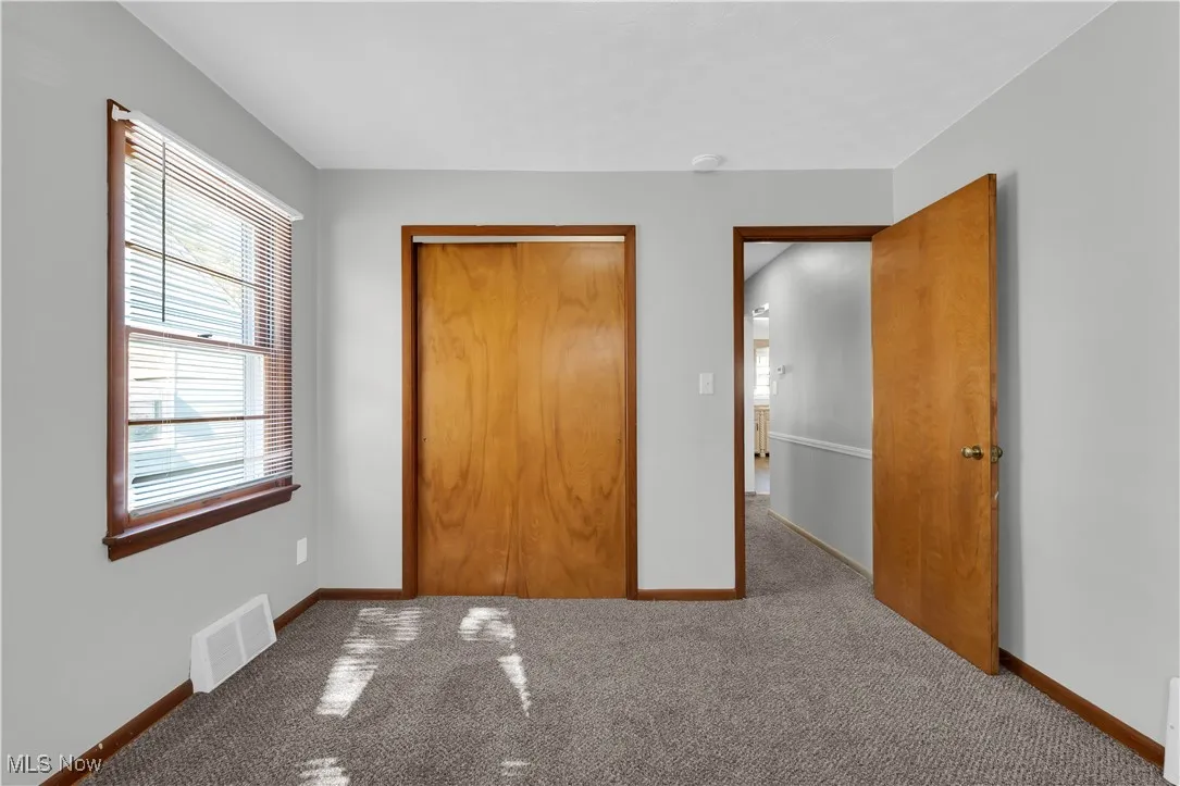 Unfurnished bedroom featuring carpet flooring and a closet