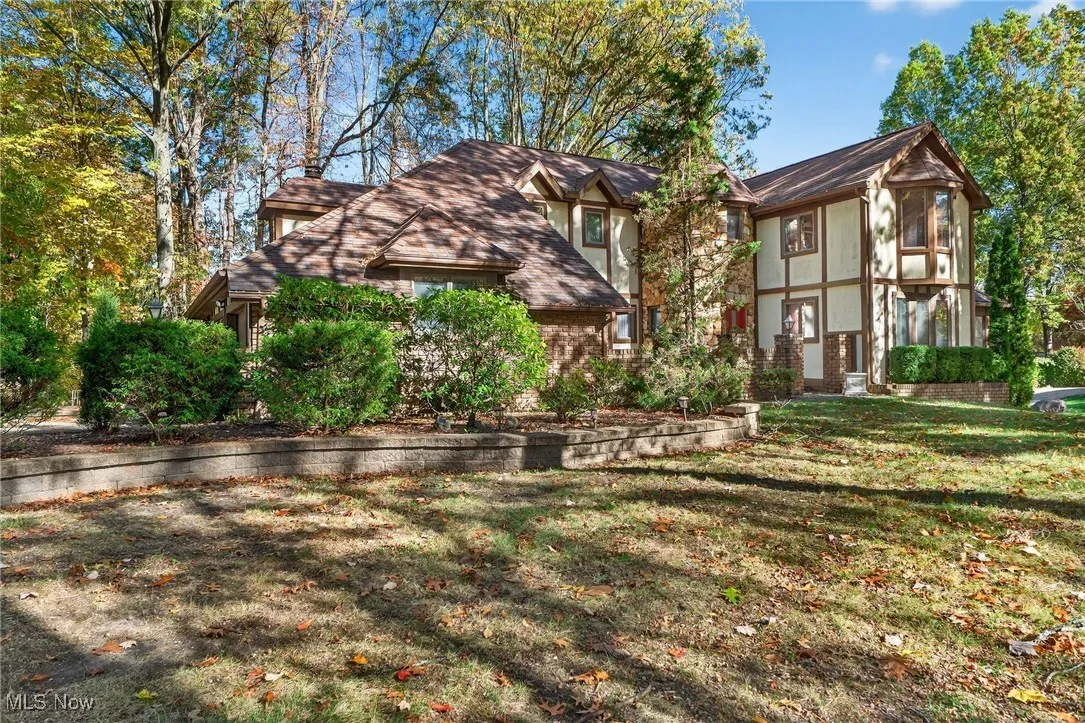 Rear view of property featuring brick siding and a lawn