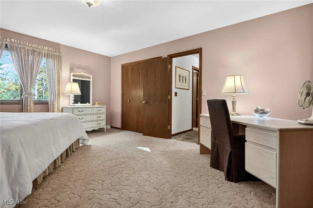 Bedroom with light colored carpet and a closet