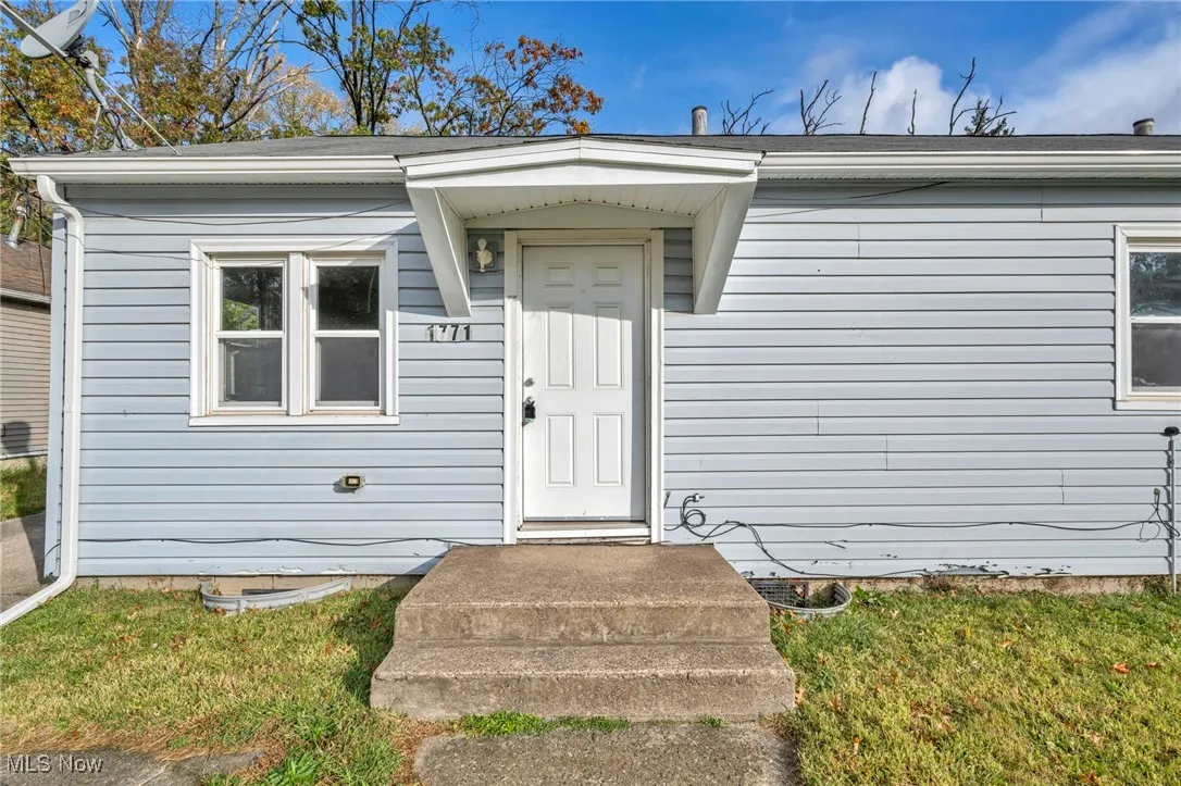 Doorway to property featuring a lawn