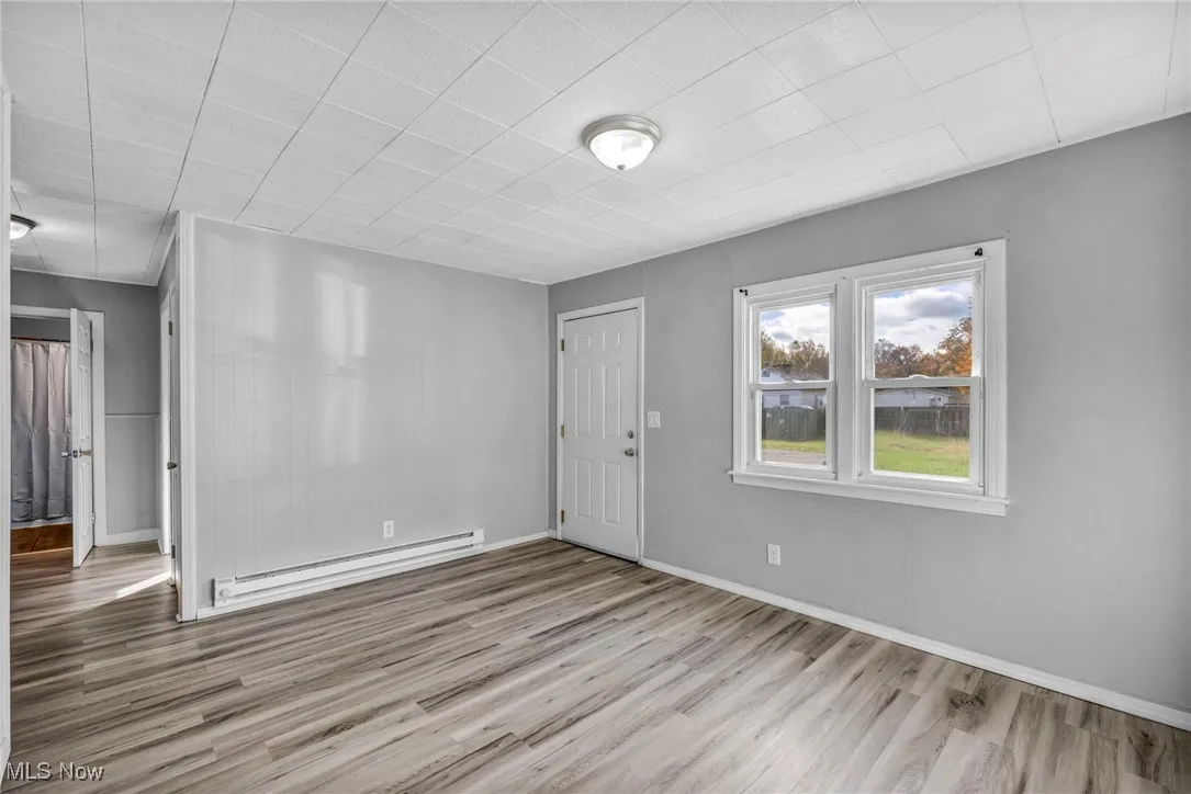 Entrance foyer featuring a baseboard heating unit and light wood finished floors