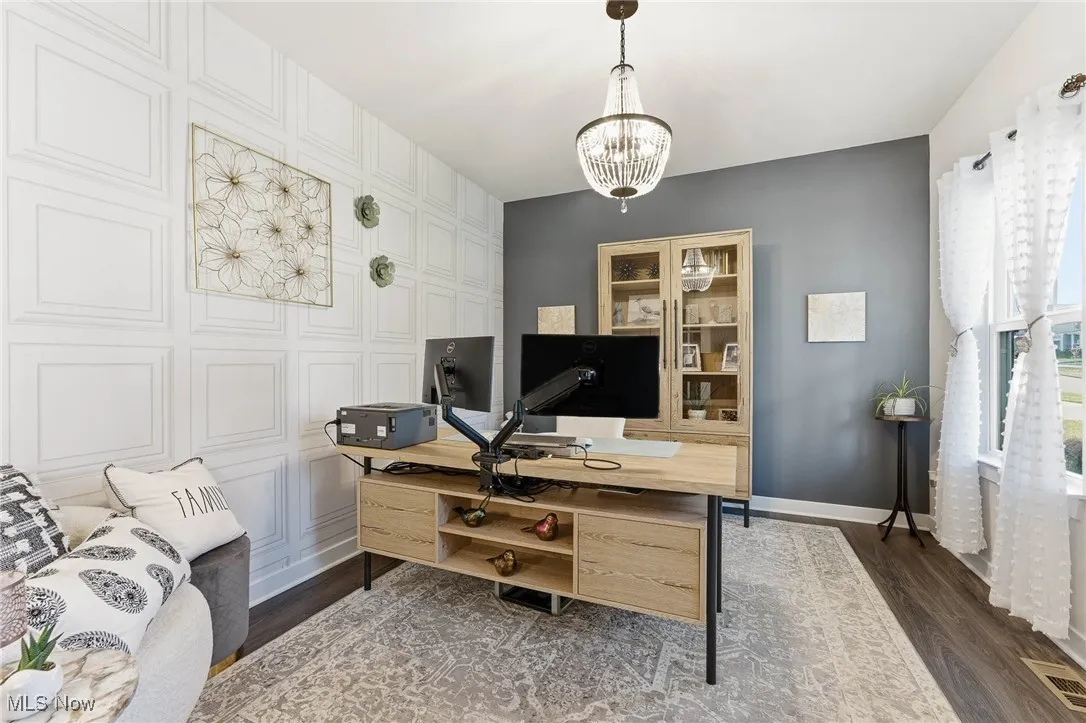 Office featuring a chandelier and dark wood-type flooring