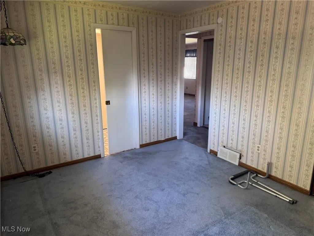 Unfurnished bedroom featuring carpet flooring and wallpapered walls