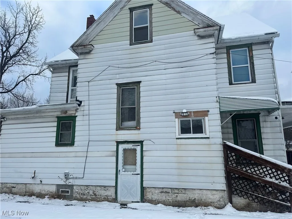 Snow covered property featuring a chimney