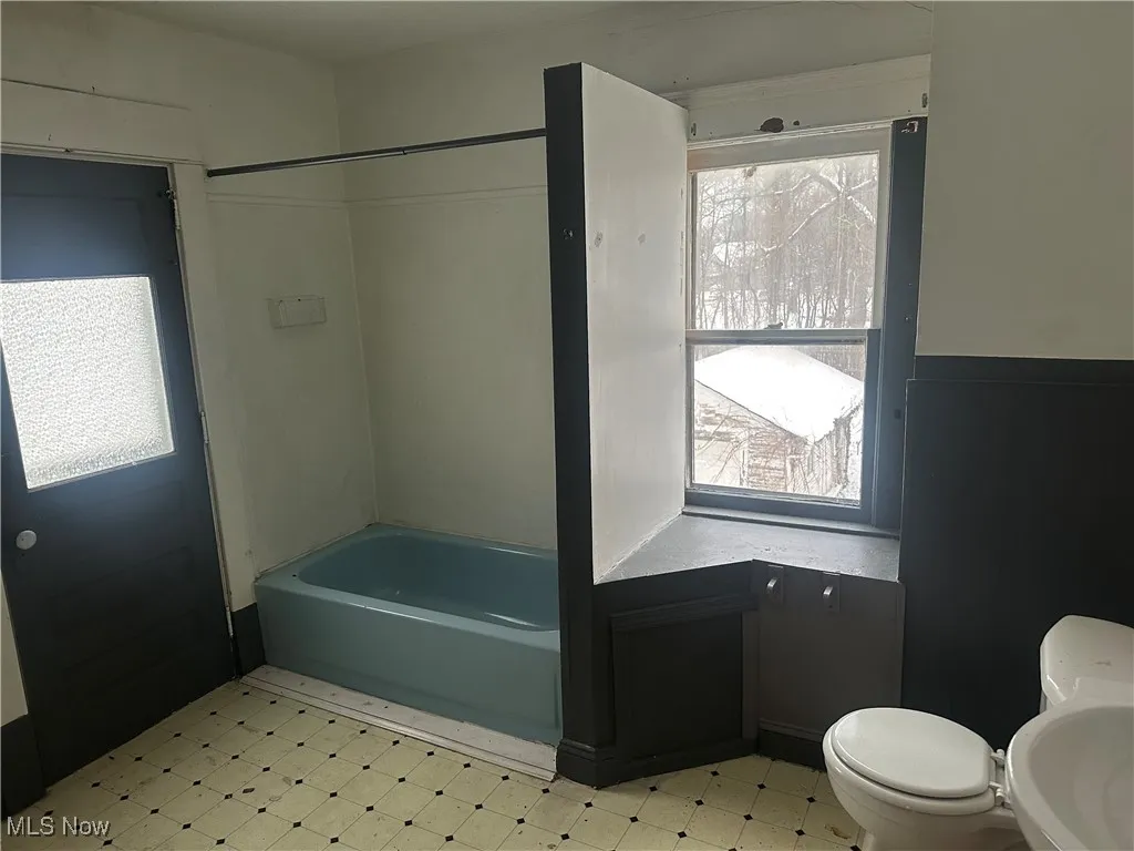 Bathroom featuring tub / shower combination and light floors