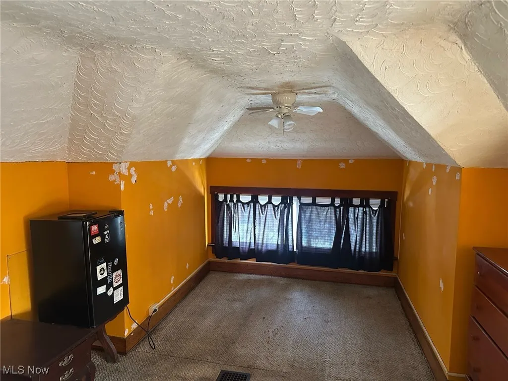 Bonus room with a textured ceiling, ceiling fan, and carpet flooring