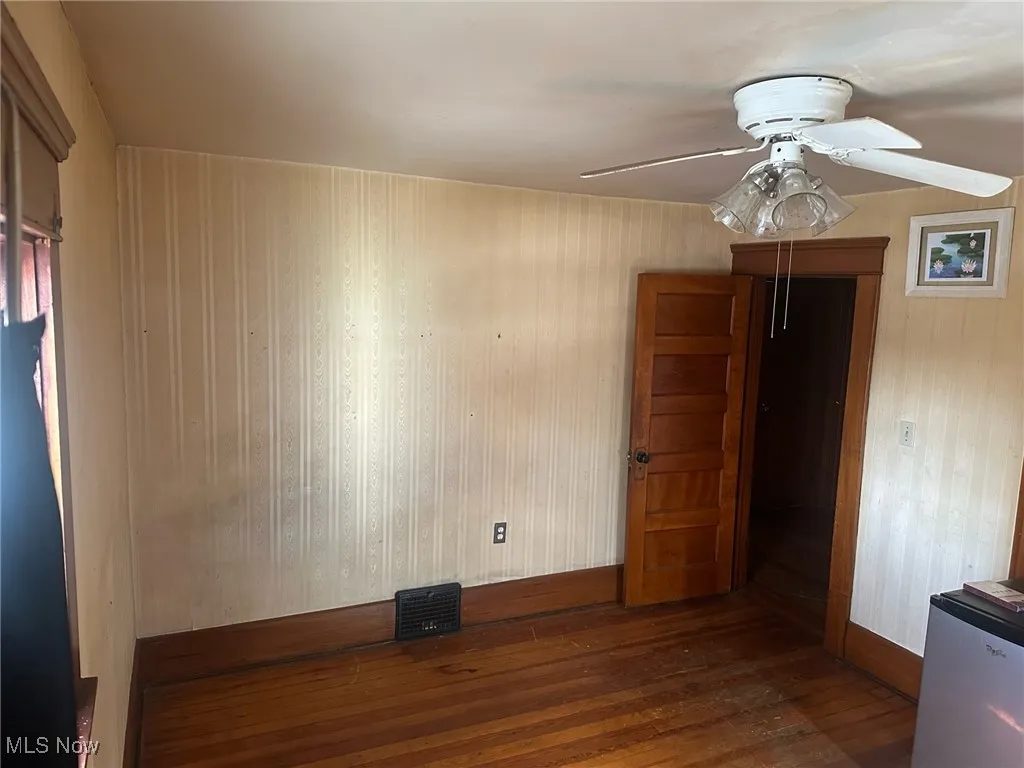 Spare room with dark wood-style flooring and ceiling fan