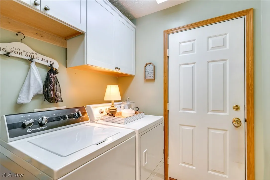 Washroom with cabinet space and washer and dryer